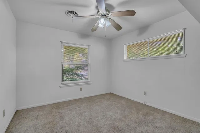 en empty room with window and ceiling fan