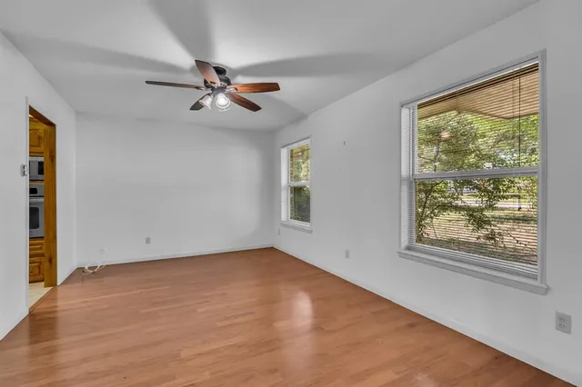 an empty room with windows and fan