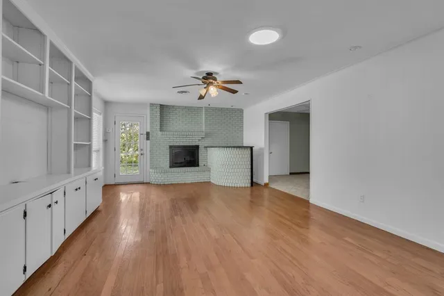 a view of an empty room with a fireplace and a window
