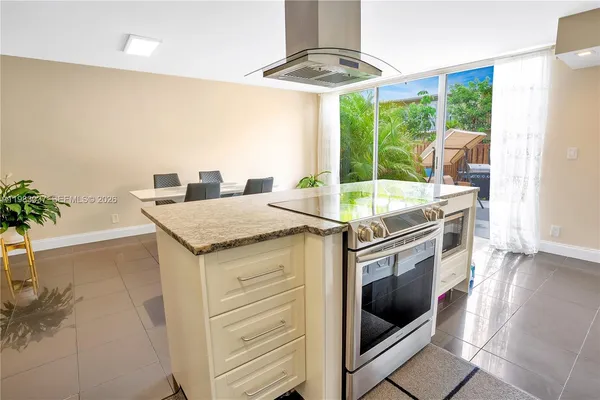 a kitchen with granite countertop a stove a sink and a microwave