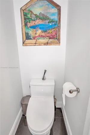 a white toilet sitting next to a white wall