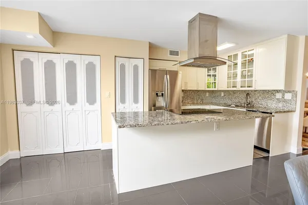 a kitchen with granite countertop white cabinets and sink