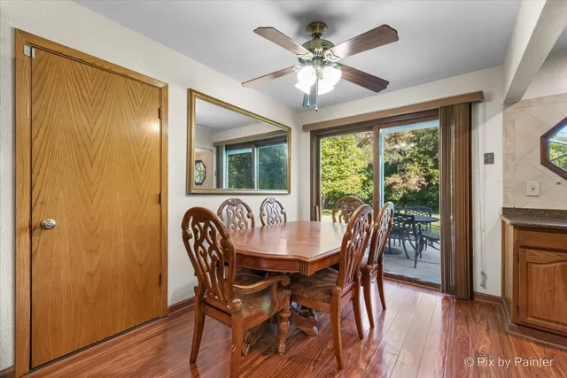 a dining room with furniture a chandelier and wooden floor
