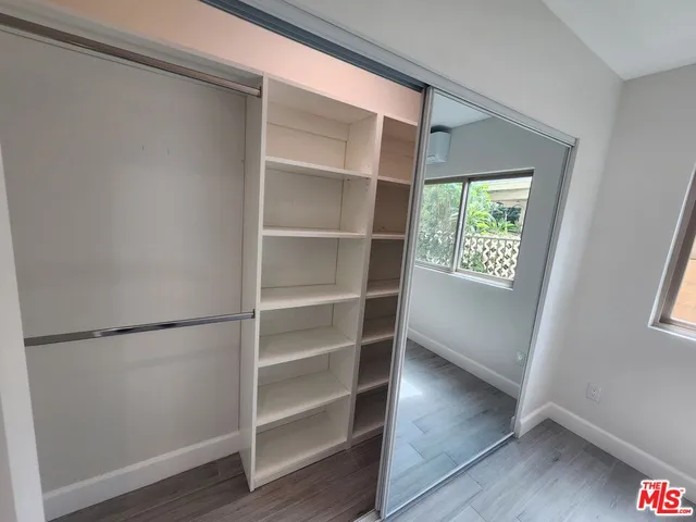 an empty room with wooden floor and entrance