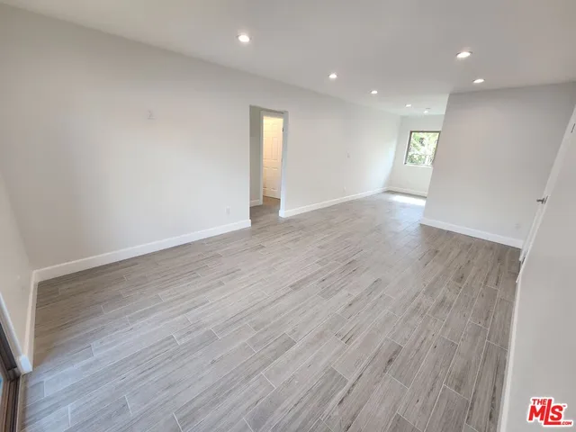 a view of an empty room with wooden floor