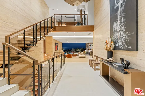a living room with lots of furniture and a floor to ceiling window