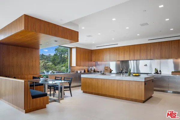 a dining room with a table chairs and a kitchen view