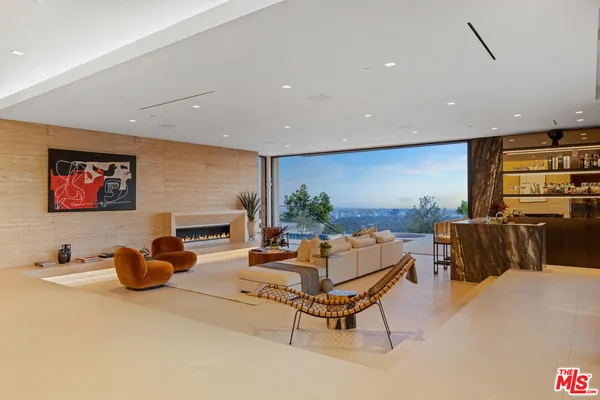 a living room with furniture and a floor to ceiling window