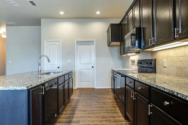 a kitchen with stainless steel appliances granite countertop counter space a sink and cabinets