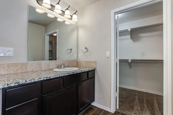 a bathroom with a granite countertop sink a toilet and bathtub