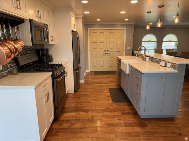 362 East 9150th Street South Sandy, UT 84070 - Photo 8 of 41 Kitchen featuring stainless steel appliances, an island with farm sink, a breakfast bar, tasteful backsplash, and solid hickory flooring