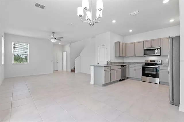 a kitchen with kitchen island white cabinets and stainless steel appliances