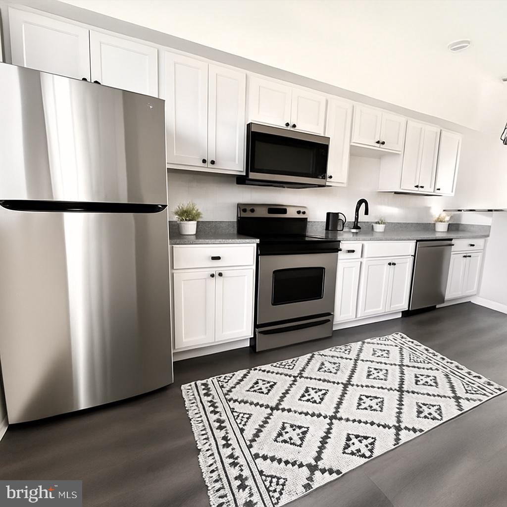 624 North Payson Street Baltimore, MD 21217 - Photo 2 of 8 a kitchen with stainless steel appliances granite countertop a refrigerator stove a sink and a microwave