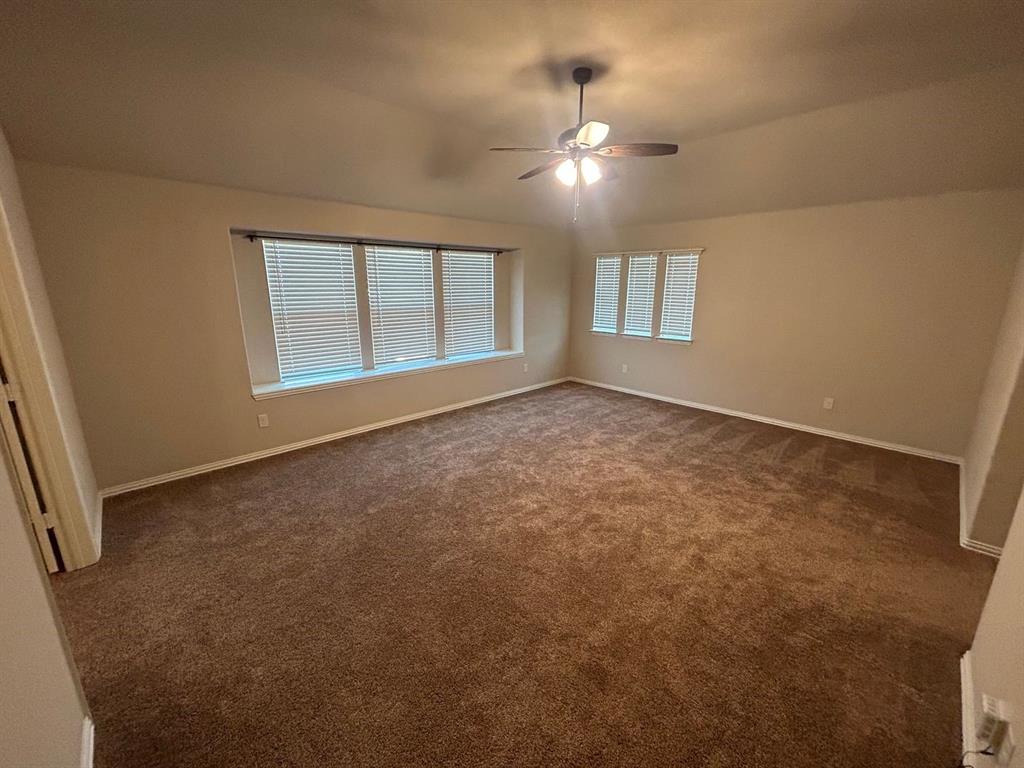2003 Cheshire Way Forney, TX 75126 - Photo 17 of 35 an empty room with chandelier fan and windows