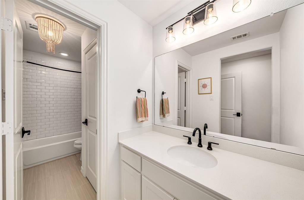 8288 Western The Colony, TX 75056 - Photo 25 of 40 a bathroom with a granite countertop sink mirror and a bathtub