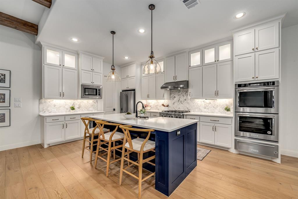 8288 Western The Colony, TX 75056 - Photo 3 of 40 a kitchen with stainless steel appliances kitchen island granite countertop a sink stove and white cabinets