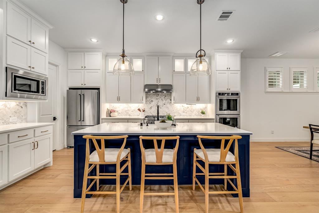 8288 Western The Colony, TX 75056 - Photo 9 of 40 a kitchen with kitchen island granite countertop a dining table chairs sink and microwave