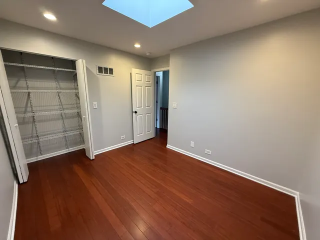 an empty room with wooden floor and closet