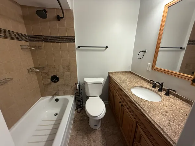 a bathroom with a granite countertop sink toilet and shower