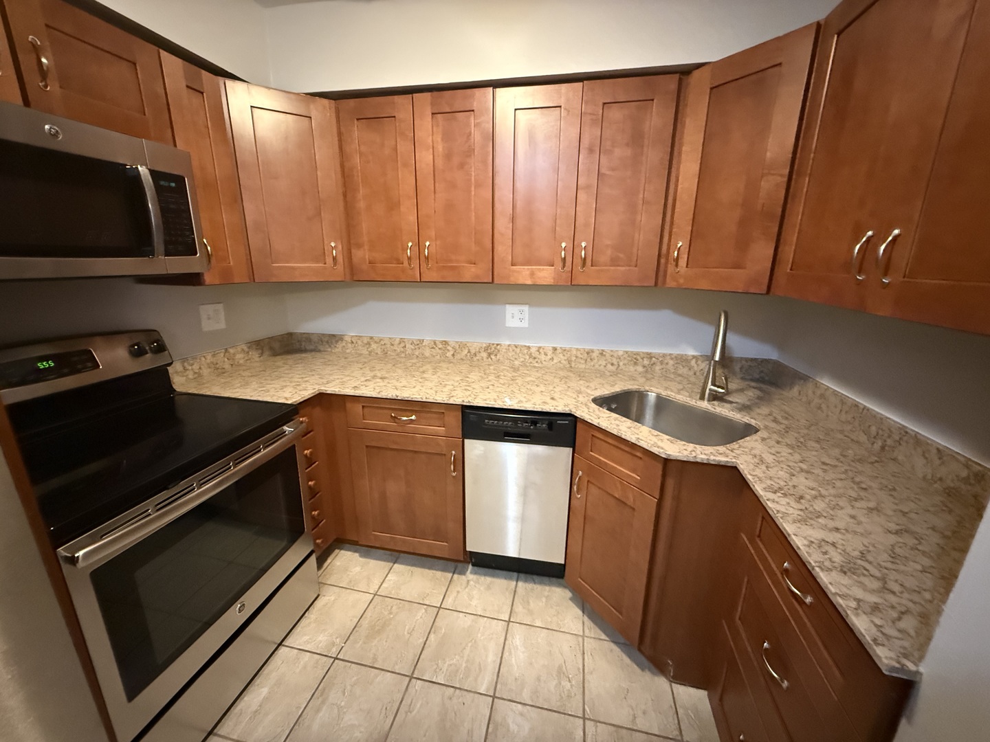 744 West Gordon Terrace, Unit 307 Chicago, IL 60613 - Photo 5 of 12 a kitchen with granite countertop a sink dishwasher stove and cabinets with wooden floor