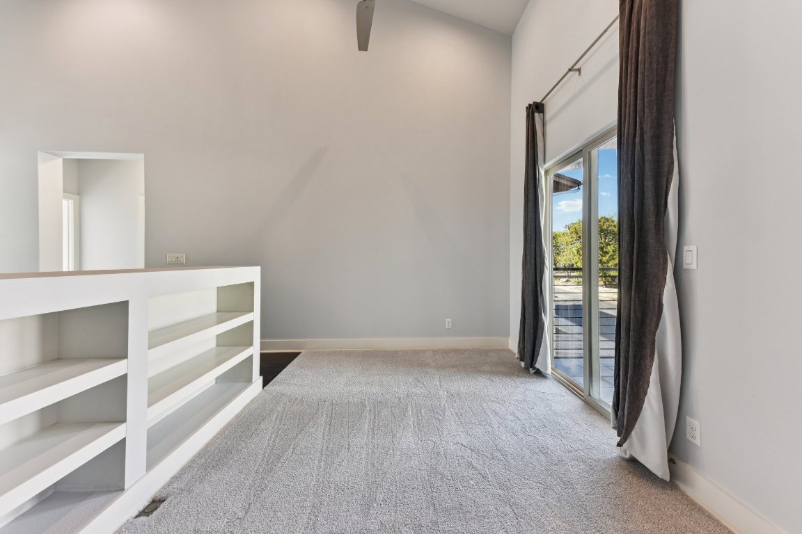 8110 Ranch Road 2222, Unit 98 Austin, TX 78730 - Photo 16 of 37 Empty room featuring light colored carpet and a towering ceiling