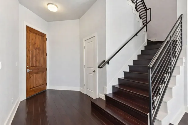a view of staircase with wooden floor and white walls