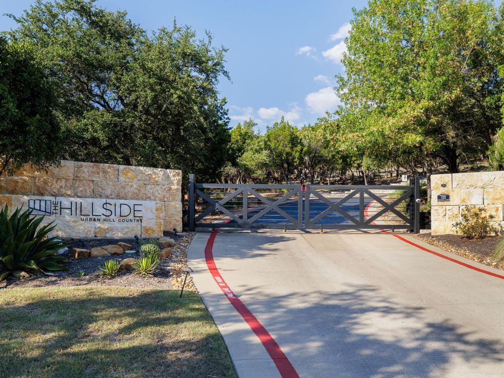 8110 Ranch Road 2222, Unit 98 Austin, TX 78730 - Photo 34 of 37 View of asphalt road featuring a gated entry, a gate, and curbs