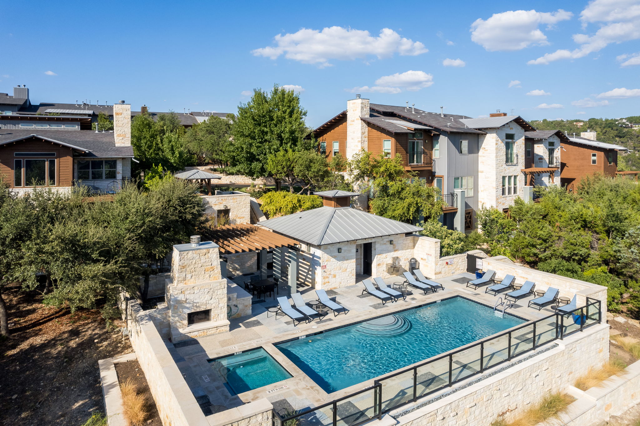 8110 Ranch Road 2222, Unit 98 Austin, TX 78730 - Photo 36 of 37 View of pool featuring a patio area, an outdoor stone fireplace, a pergola, and a pool with connected hot tub