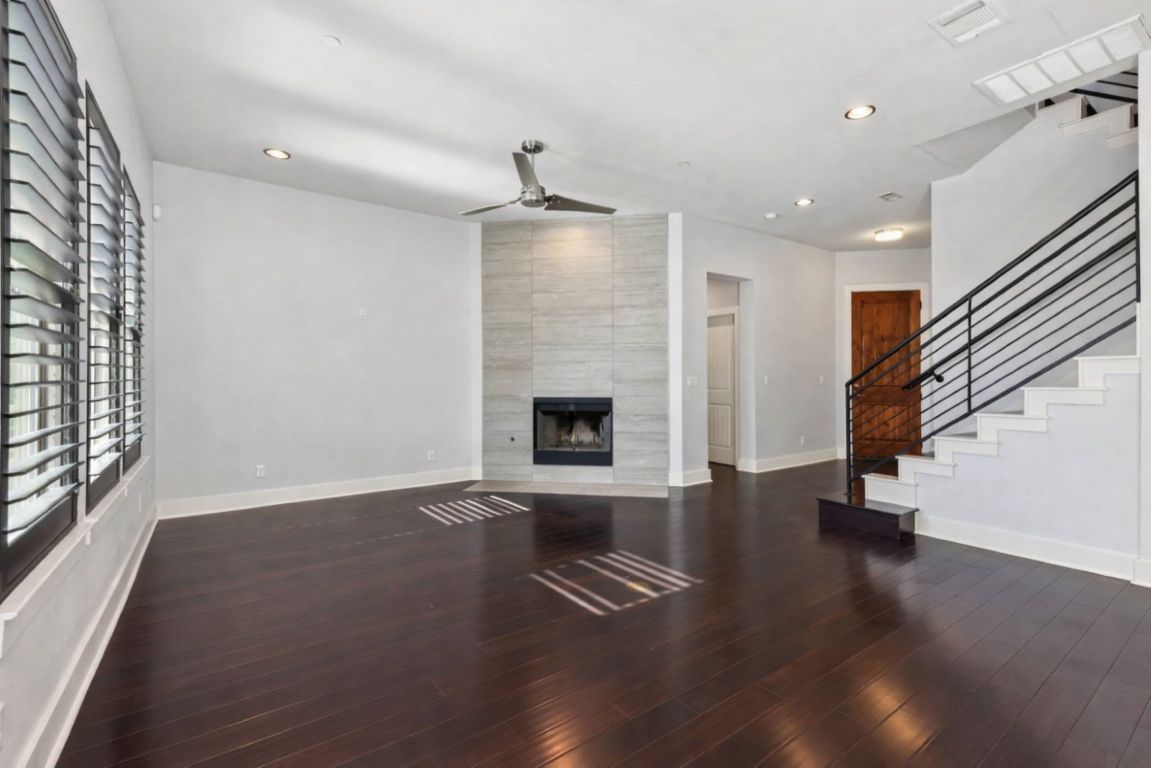 8110 Ranch Road 2222, Unit 98 Austin, TX 78730 - Photo 7 of 37 Unfurnished living room featuring stairway, recessed lighting, a tiled fireplace, dark wood-style floors, and a ceiling fan