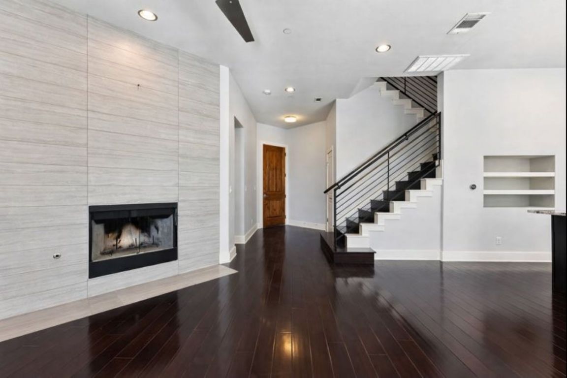8110 Ranch Road 2222, Unit 98 Austin, TX 78730 - Photo 8 of 37 Unfurnished living room with a fireplace, stairway, recessed lighting, dark wood-style floors, and built in shelves