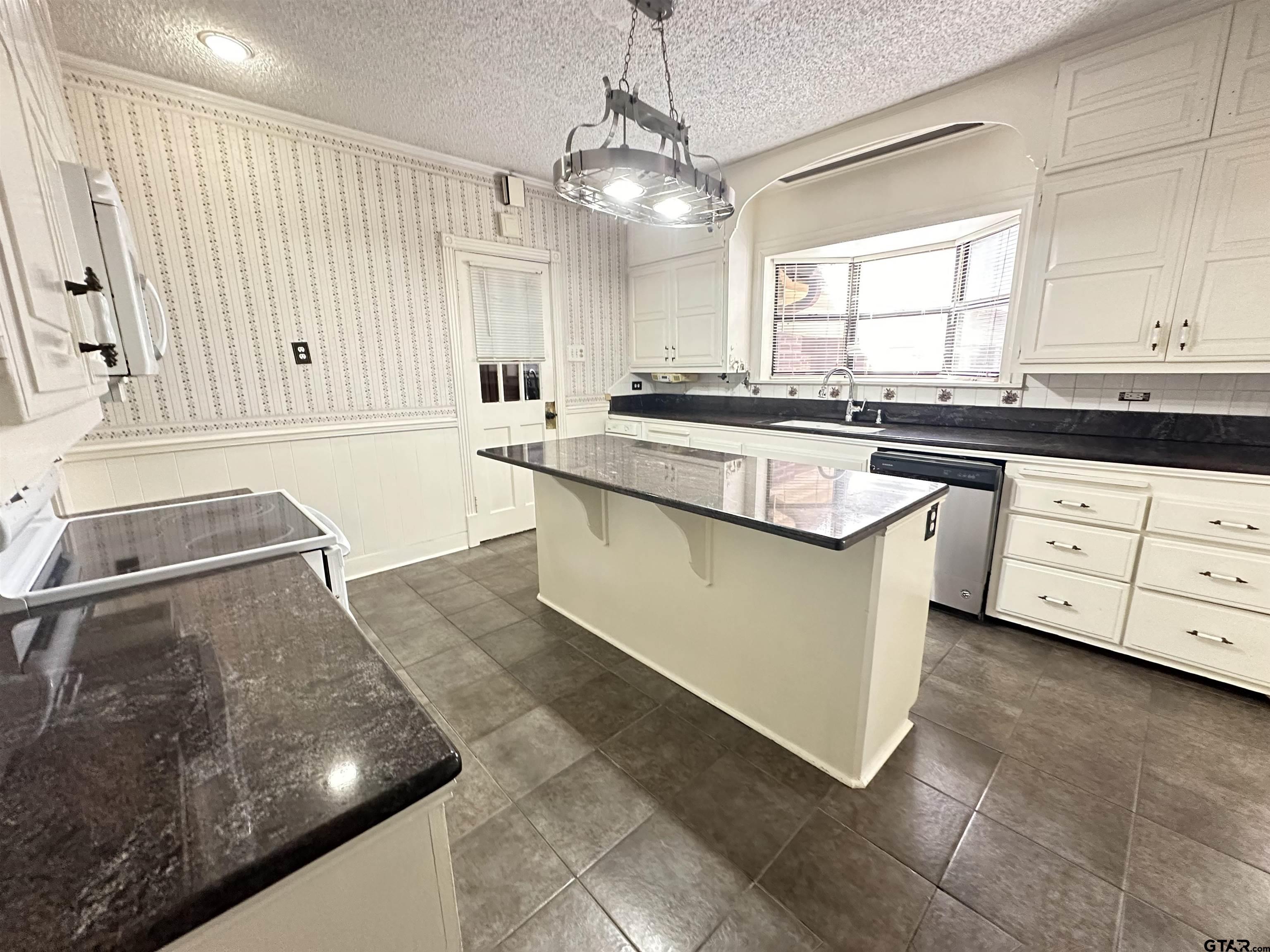 2337 East Rusk Street Jacksonville, TX 75766 - Photo 11 of 47 a kitchen with stainless steel appliances granite countertop a sink and a stove