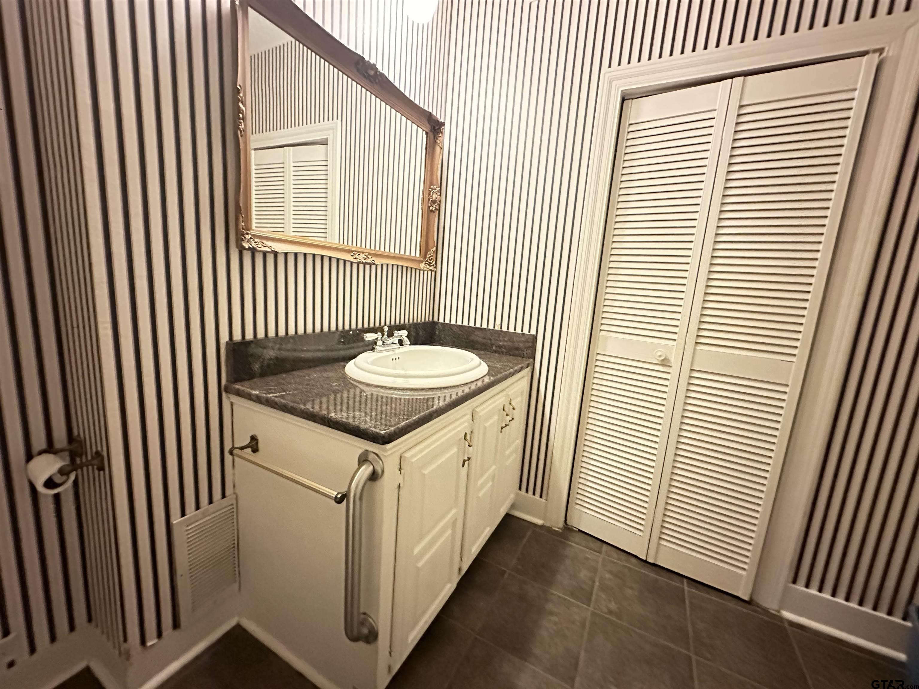 2337 East Rusk Street Jacksonville, TX 75766 - Photo 17 of 47 a bathroom with a sink and a mirror