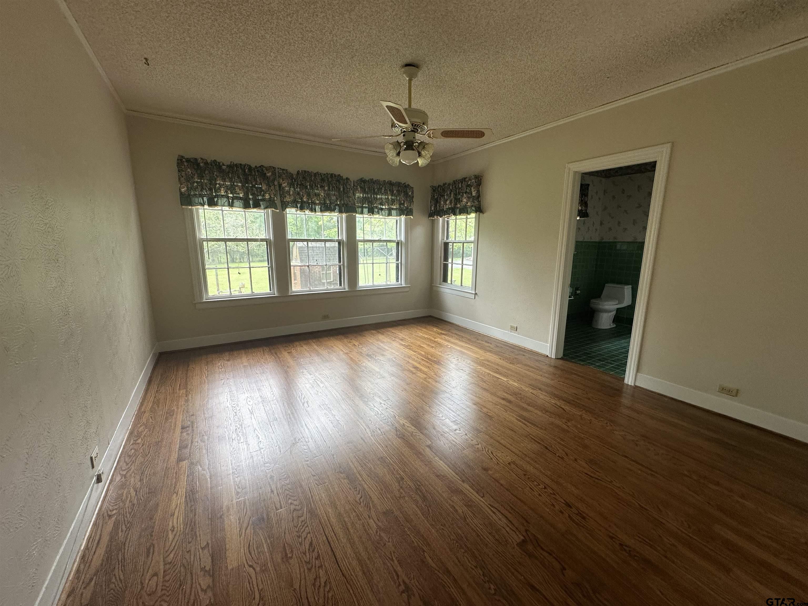 2337 East Rusk Street Jacksonville, TX 75766 - Photo 23 of 47 a view of an empty room with wooden floor and a window