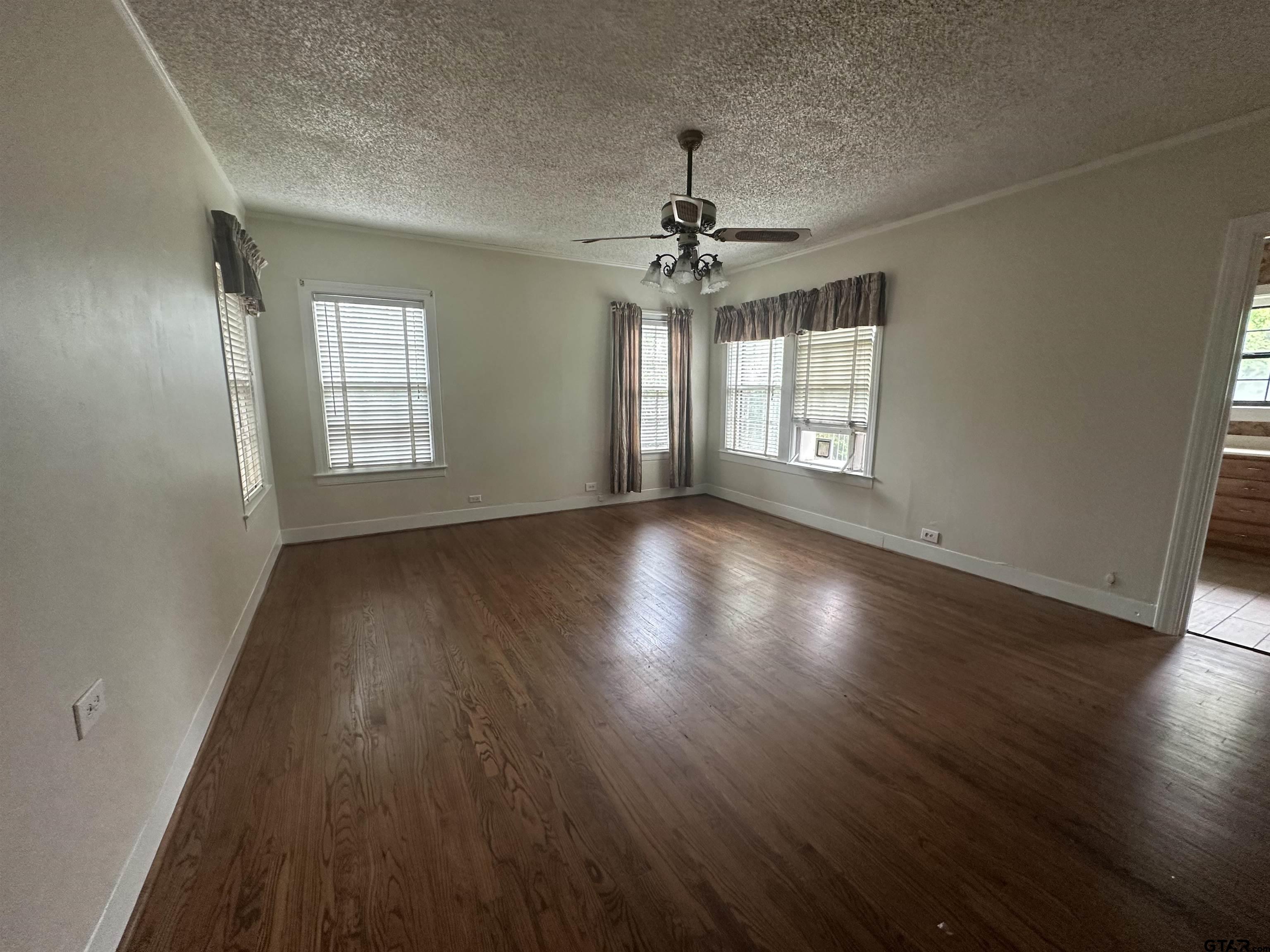 2337 East Rusk Street Jacksonville, TX 75766 - Photo 24 of 47 an empty room with wooden floor and windows