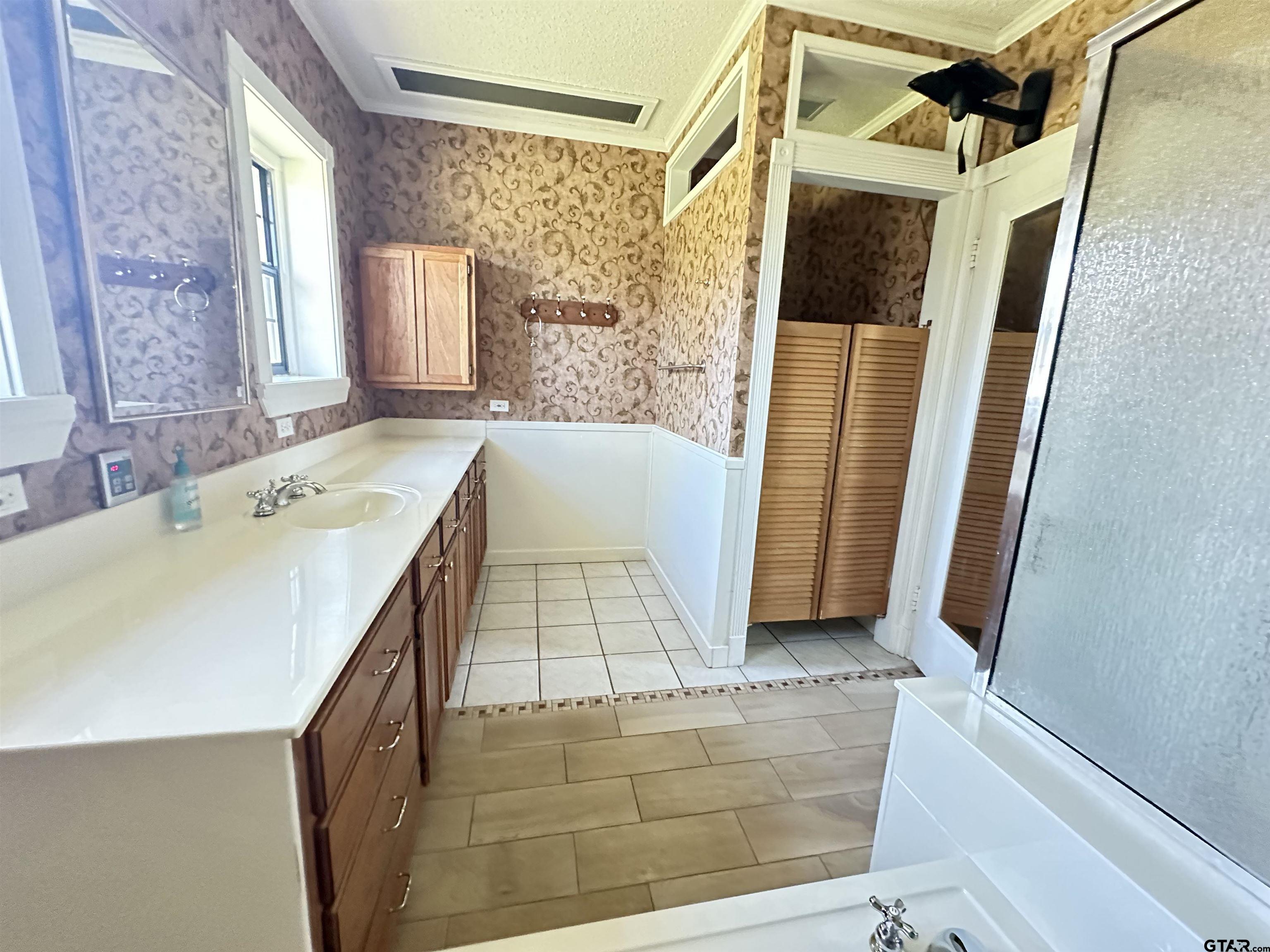 2337 East Rusk Street Jacksonville, TX 75766 - Photo 28 of 47 a bathroom with a tub a sink and a shower