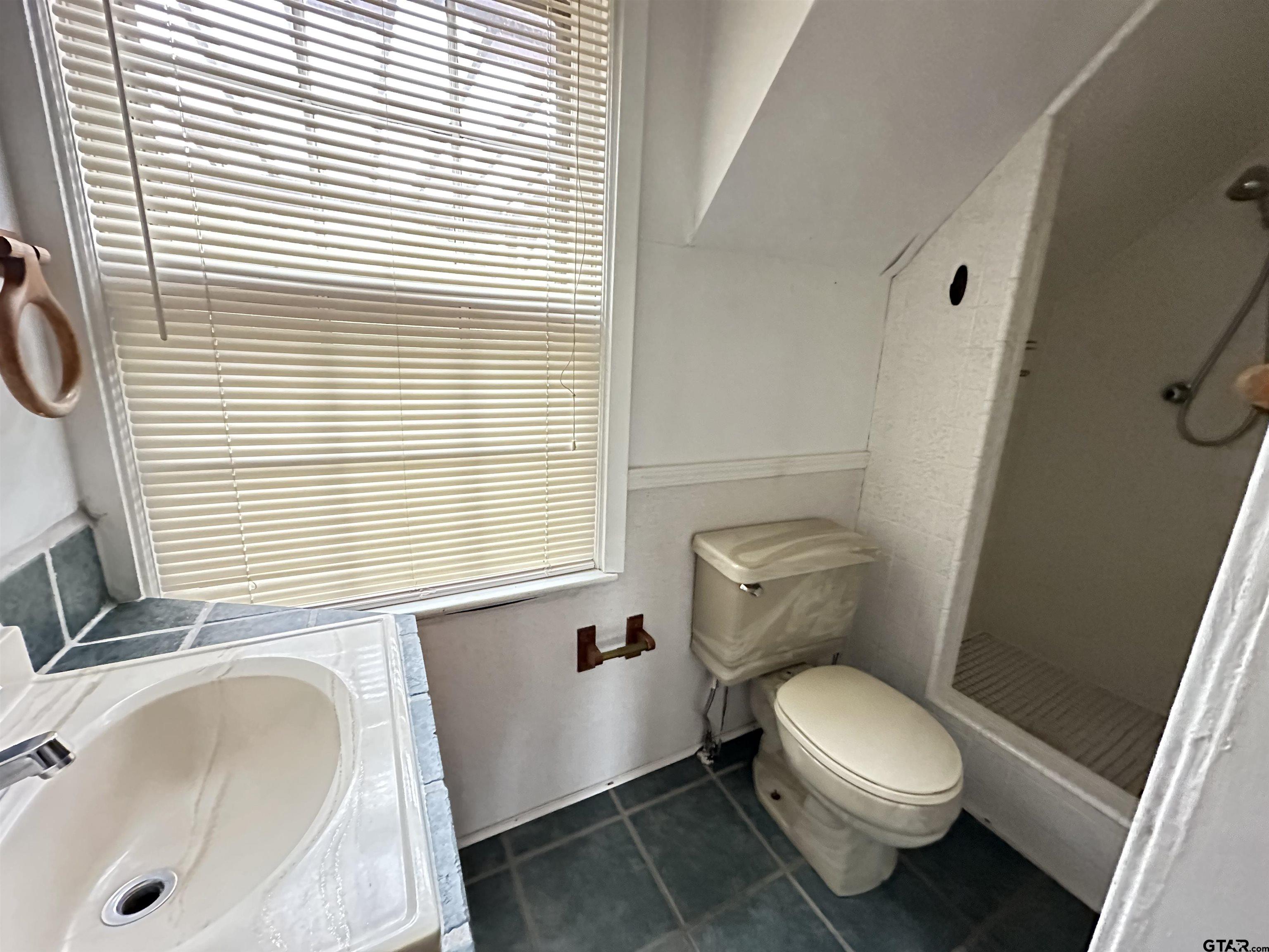 2337 East Rusk Street Jacksonville, TX 75766 - Photo 45 of 47 a white toilet sitting next to a bathroom sink