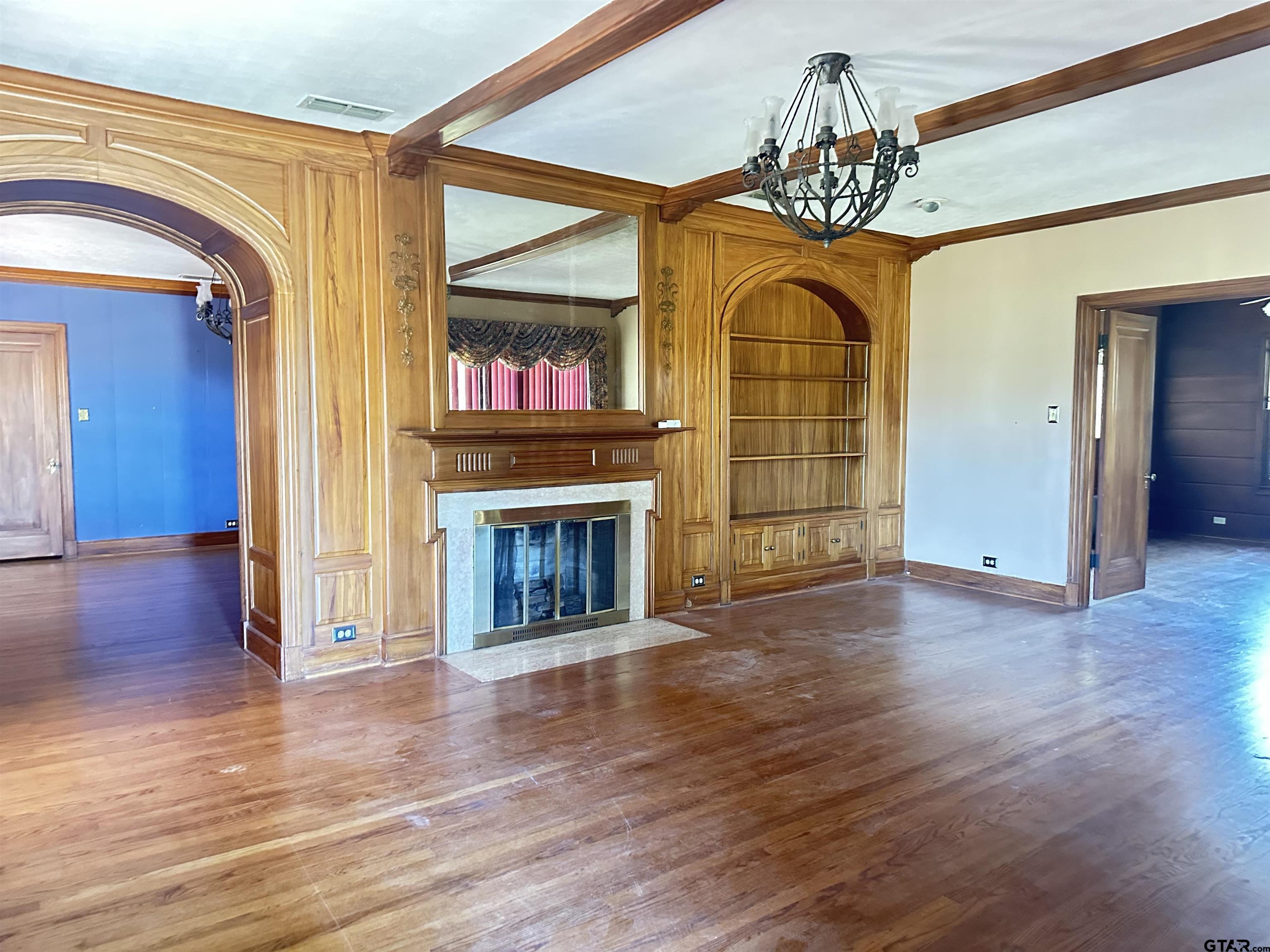2337 East Rusk Street Jacksonville, TX 75766 - Photo 5 of 47 a view of an empty room with wooden floor fireplace and a window