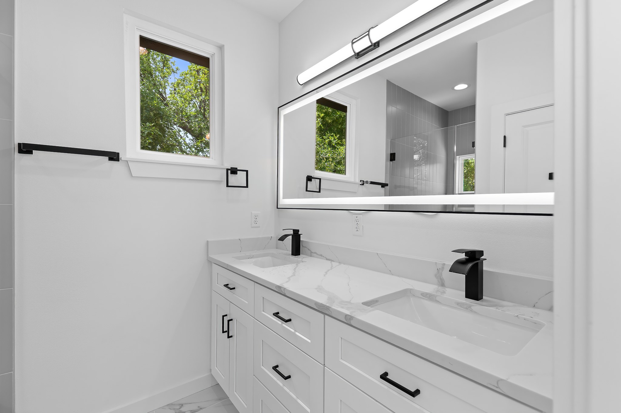 5305 Ledesma Road, Unit 4 Austin, TX 78721 - Photo 33 of 40 Dual vanity with pristine white marble-patterned countertops and sleek black fixtures.