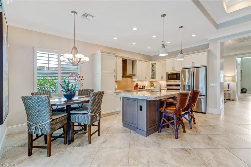 6487 Warwick Avenue Naples, FL 34113 - Photo 11 of 32 a view of a dining room and livingroom with furniture wooden floor a chandelier