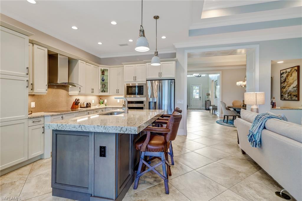 6487 Warwick Avenue Naples, FL 34113 - Photo 12 of 32 a kitchen with stainless steel appliances kitchen island granite countertop a sink and cabinets