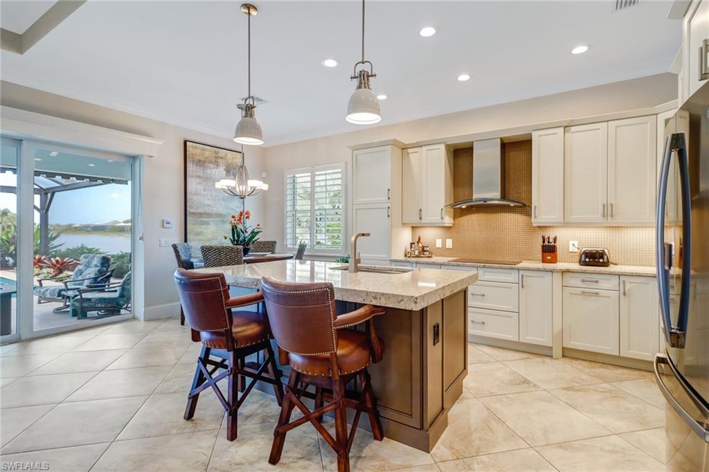 6487 Warwick Avenue Naples, FL 34113 - Photo 13 of 32 a kitchen with a table chairs sink and cabinets