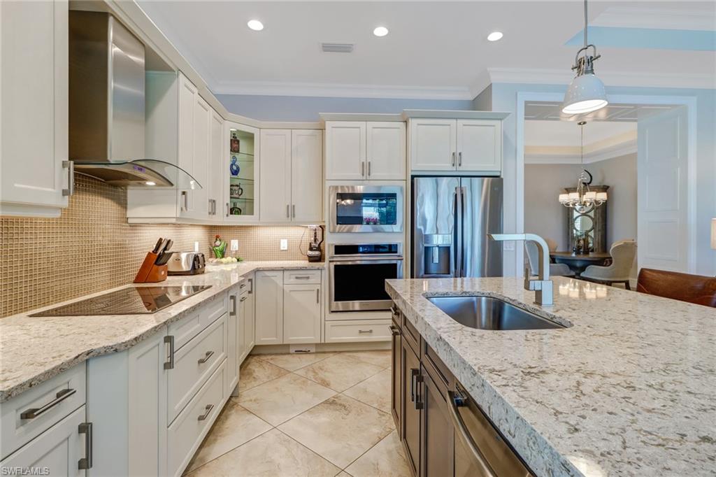 6487 Warwick Avenue Naples, FL 34113 - Photo 14 of 32 a kitchen with granite countertop a sink stove and refrigerator