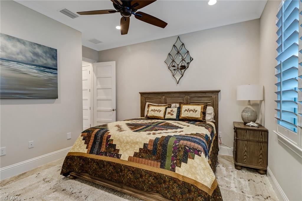 6487 Warwick Avenue Naples, FL 34113 - Photo 16 of 32 a bedroom with a bed and a painting on the wall