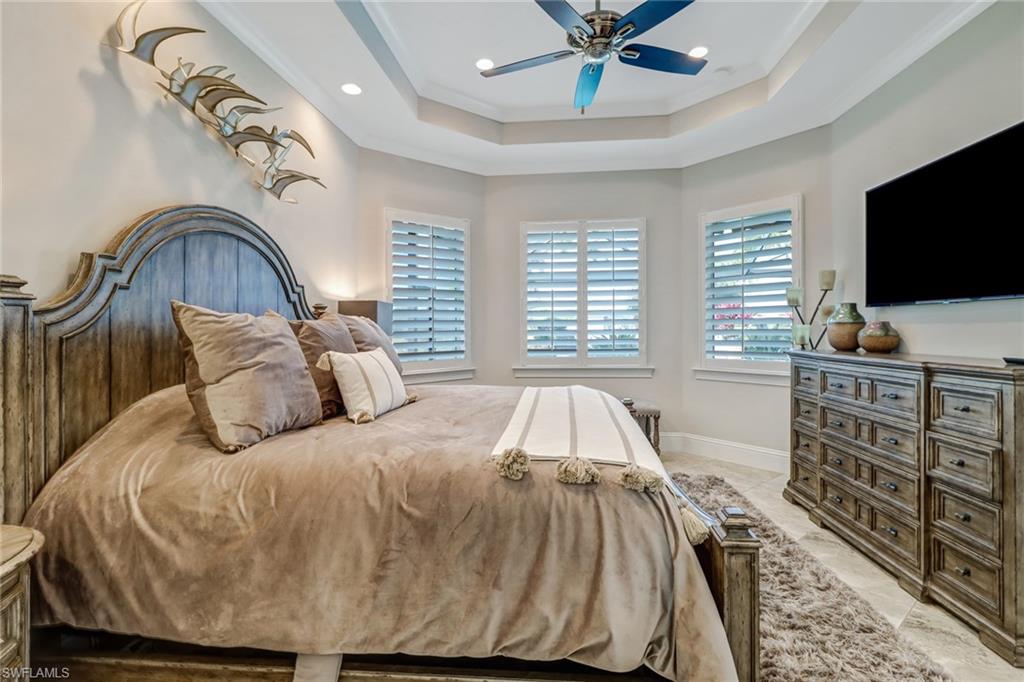 6487 Warwick Avenue Naples, FL 34113 - Photo 19 of 32 a bedroom with a bed and a flat screen tv