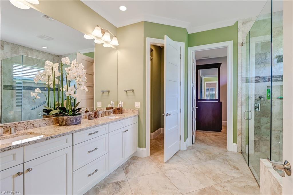 6487 Warwick Avenue Naples, FL 34113 - Photo 20 of 32 a spacious bathroom with a double vanity sink a large mirror and a shower