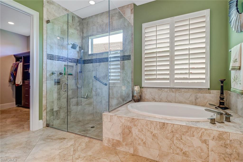 6487 Warwick Avenue Naples, FL 34113 - Photo 21 of 32 a spacious bathroom with a granite countertop tub shower and sink