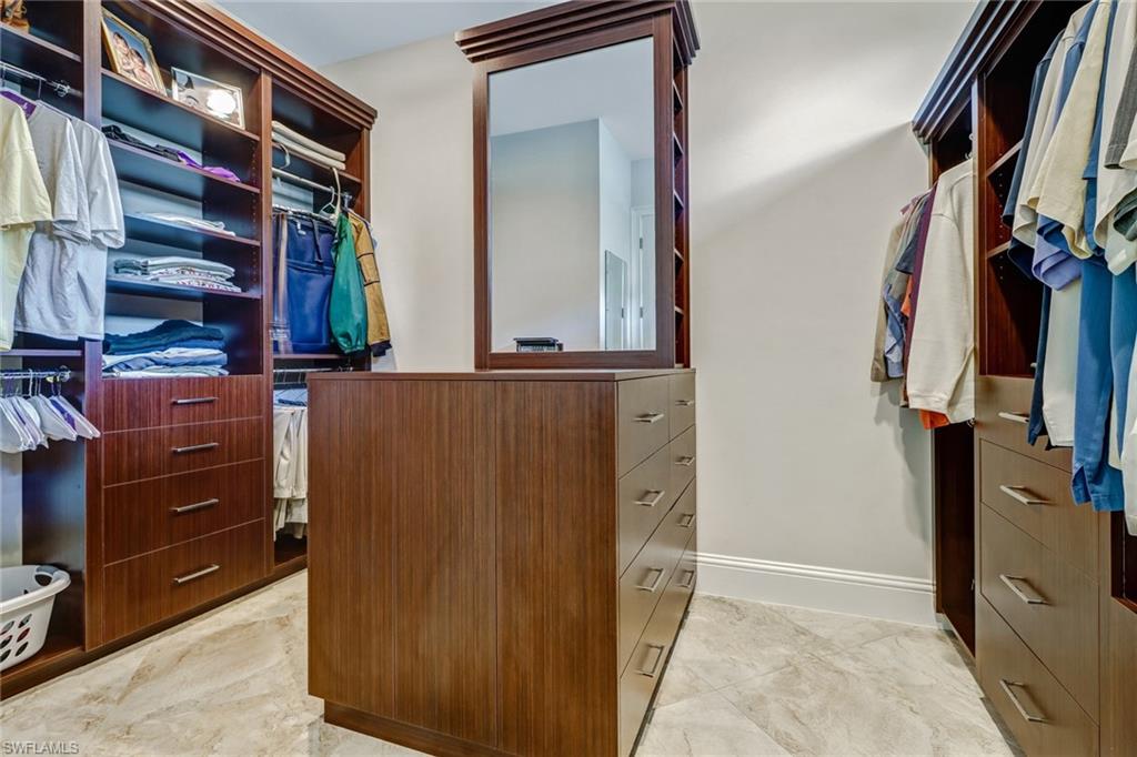 6487 Warwick Avenue Naples, FL 34113 - Photo 22 of 32 a view of walk in closet with clothes and shoes