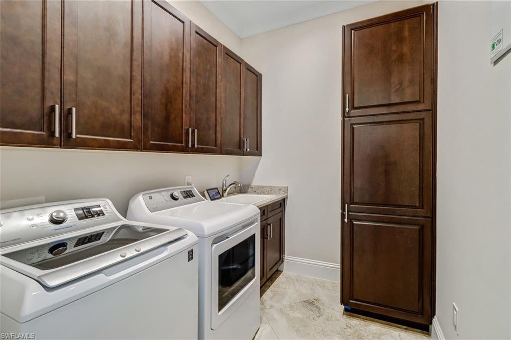 6487 Warwick Avenue Naples, FL 34113 - Photo 23 of 32 a kitchen with a refrigerator sink and cabinets