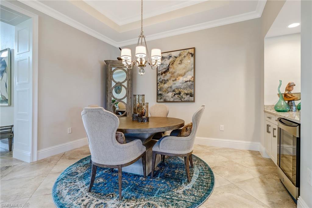 6487 Warwick Avenue Naples, FL 34113 - Photo 8 of 32 a view of a dining room with furniture a chandelier and wooden floor