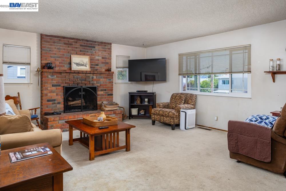4591 Edwards Lane Castro Valley, CA 94546 - Photo 12 of 44 a living room with furniture flat screen tv and a fireplace